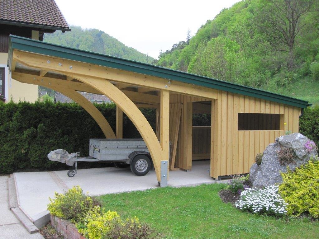 Hütte mit langem Vordach aus hellem Holz mit geschwungenen Seitenbalken