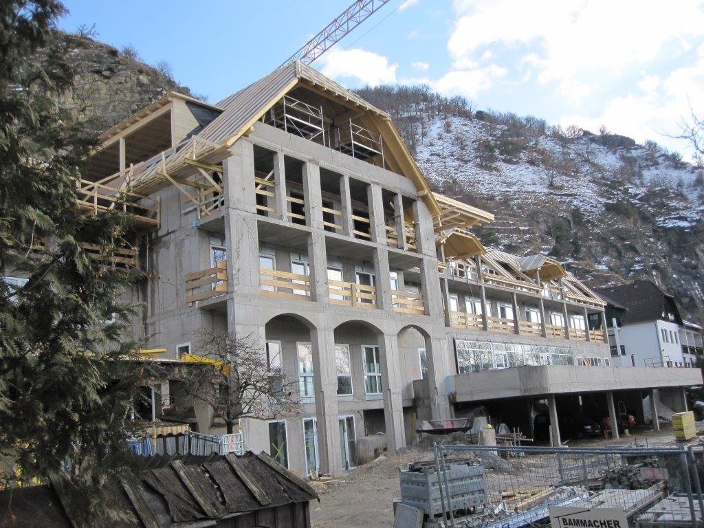 Mehrstöckiges Haus an einem Felsen im Rohbau mit neuem Dachstuhl