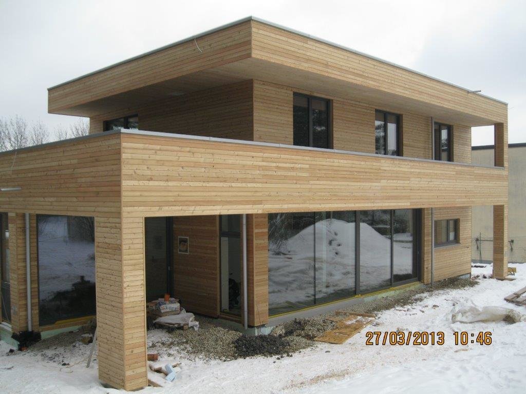 Haus mit durchgehender Holzfassade und langer Fensterfront im Erdgeschoß