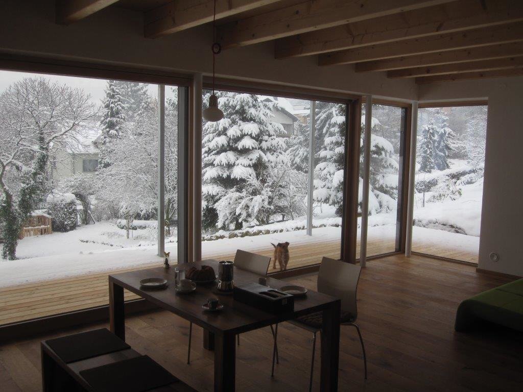 Lange Fensterfront im Erdgeschoß mit Blick in den winterlichen Garten