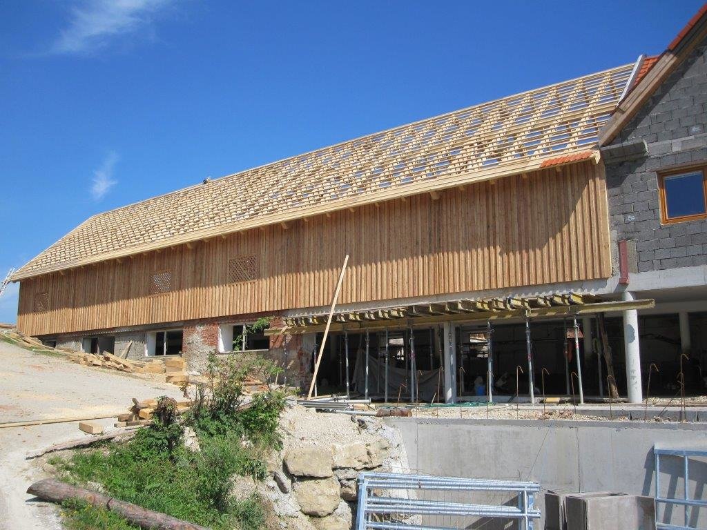 Langes Wirtschaftsgebäude aus Holz mit fertigem Dachstuhl