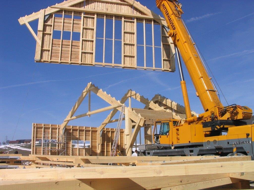 Holzfassade wird mit Kran hochgehoben und platziert